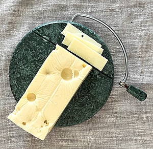 Cutting thin slices of swiss cheese from a rectanglar block