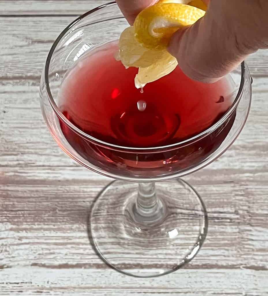 Adding a squeeze of lemon to the Coupe Glass