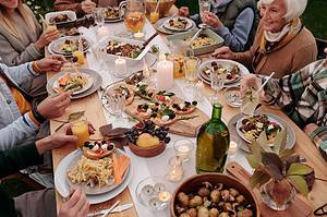 Table of Mediterranean feast - kabobs, pitas, roasted eggplant and more.