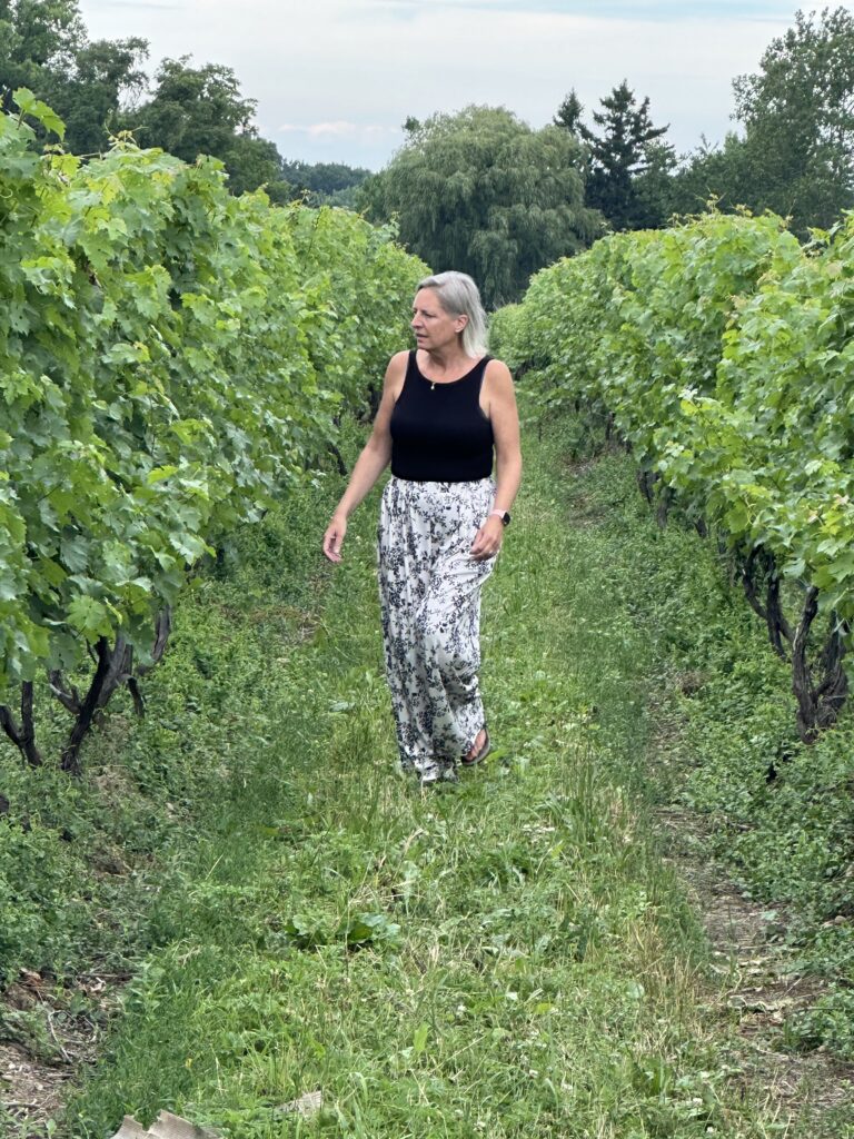 Anne walking down between two vineyard rows at 21 Brix winery