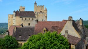 Photo of French buildings from the Middle Ages. Beige walls and red or brown clay rooftops.
