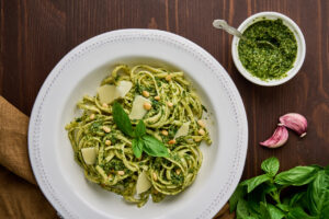 Classic italian pasta pesto with pine nuts, pound garlic, basil leaves, hard parmesan cheese and extra-vitgin olive oil. Mediterranean pesto sauce and tagliatelle. Healthy homemade vegetarian. Herbal dish