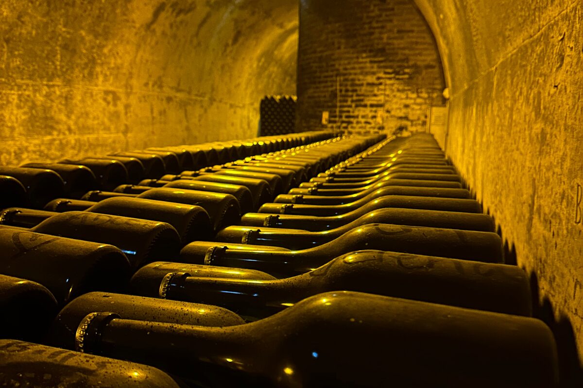 Thousands of unlabeled wine bottles line the walls of chalk caves in the Champagne wine region.
