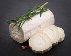 Fresh goat cheese on a slate topped with rosemary