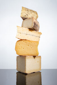 An assortment of hard cheeses in a pyramid