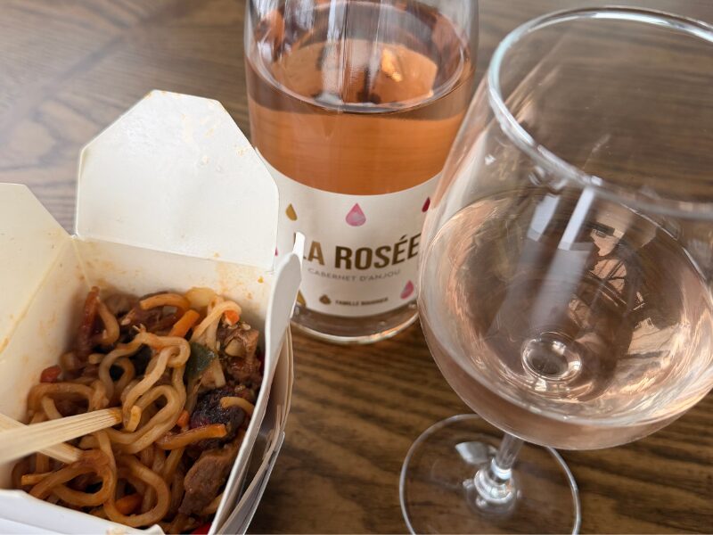 Image shows a wine bottle of Rosé d'Anjou with Korean beef noodles in a Chinese take-out container and a glass of the Rosé