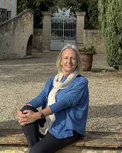 Anne seated on the wall surrounding a French Chateau in the Rhone countryside