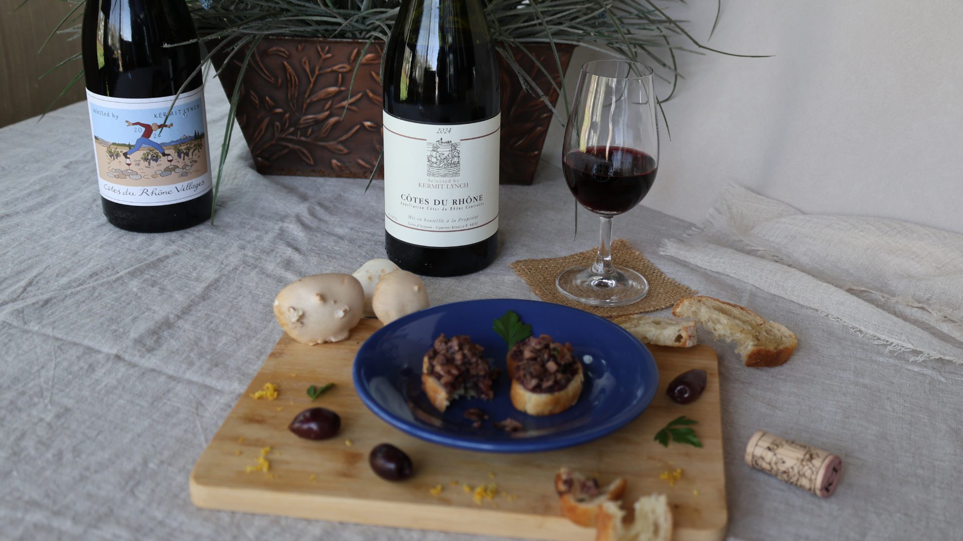 CDR + Mushroom w_ Wine Bottles 1920×1080 Small plate of mushroom and olive tapenade crostini with bottles of Cote du Rhone