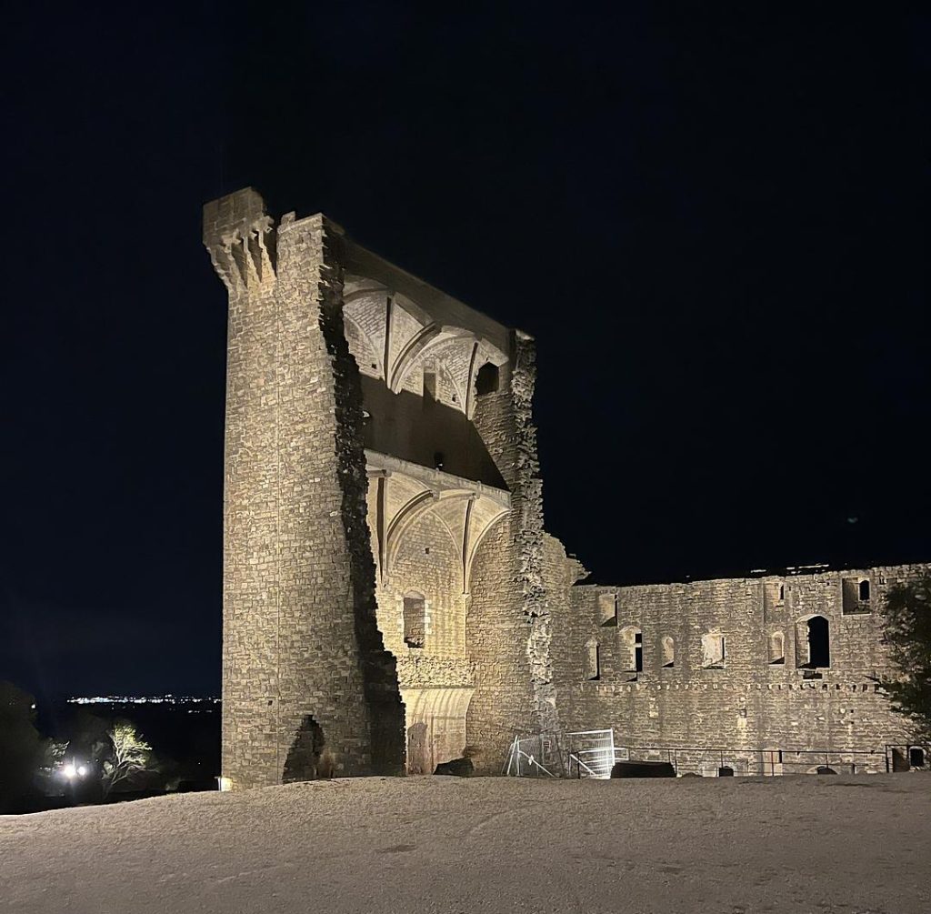 Original ruins of Chateauneuf-du-Pape lit up at night.