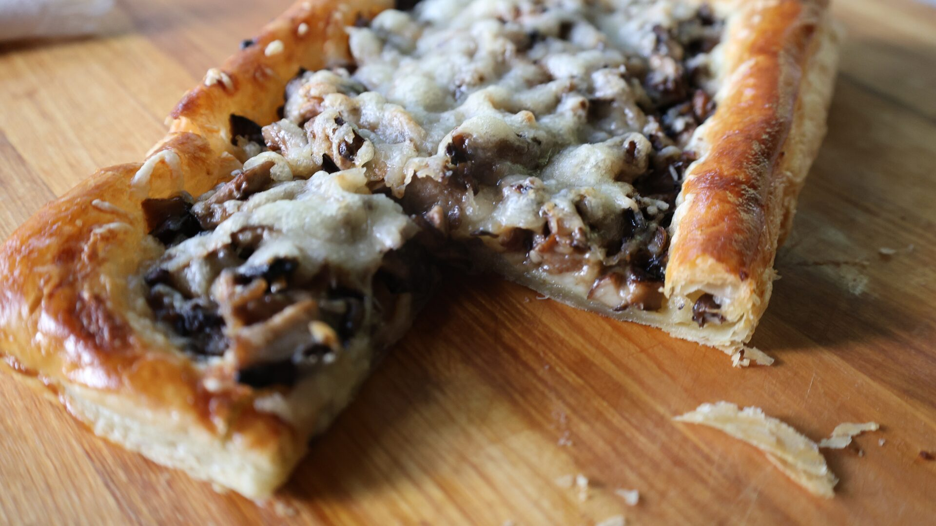 Mushroom Gruyere Tart - Bite Shot 1920x1080 Closeup shot of flaky puff pastry covered in roasted mushrooms and gruyere cheese